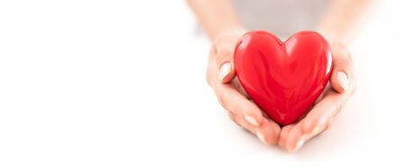 The woman is holding a red heart. Concept for charity, health insurance, love, international cardiology day.の写真素材