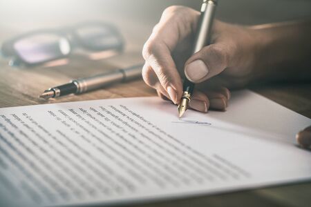 Business woman signing contract document on office desk, making a deal.の写真素材