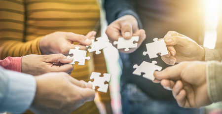 A group of business people assembling jigsaw puzzle. The concept of cooperation, teamwork, help and...