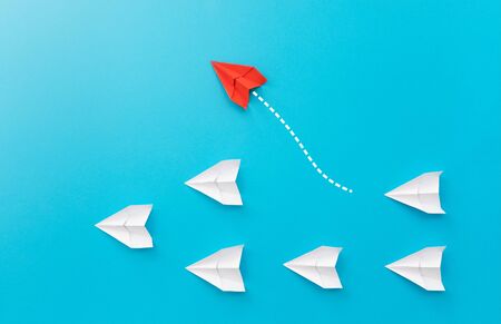 New ideas creativity and different innovative solution. Business concept. A group of paper airplanes, one plane is flying in the other direction, different way.の写真素材