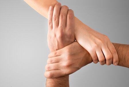 Top view of young people holding hands. Symbol and concept of unity, teamwork and support.の写真素材