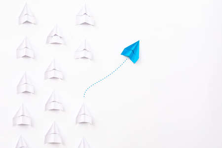 New ideas creativity and different innovative solution. Business concept. A group of paper airplanes, one plane is flying in the other direction, different way.の写真素材