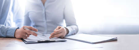 Business people negotiating a contract. Human hands working with documents at desk and signing contract.の写真素材
