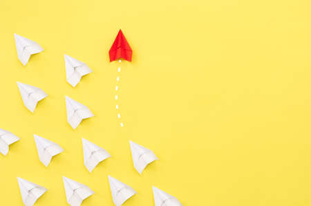 New ideas creativity and different innovative solution. Business concept. A group of paper airplanes, one plane is flying in the other direction, different way.の写真素材