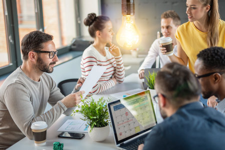 Young business people are discussing together a new startup project. A glowing light bulb as a new...