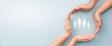 Hands with cut out paper silhouette on table. Family care concept.の写真素材
