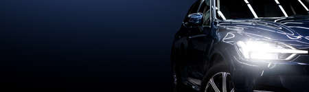 Black modern car closeup on black background.の写真素材