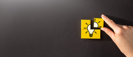 Wooden cubes with icon light bulb and human hand. Creative idea and innovation concept.