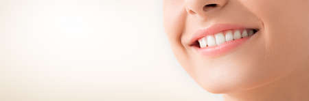 Beautiful smile young woman. White teeth on the master plan. Free space and background to use.の写真素材