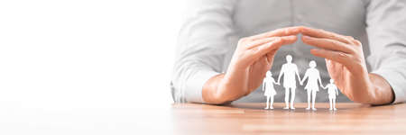 Hands with cut out paper silhouette on table. Family care concept.の写真素材