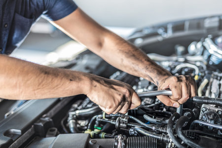 Auto mechanic working and repair on car engine in mechanics garage. Car service. Man with wrench at...