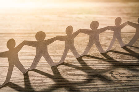 Team of paper chain people. Human chain with light and shadow.の写真素材