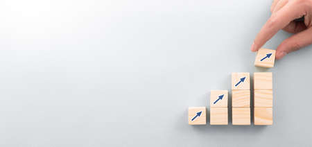 Hand arranging wood block with arrow up icon. Business concept growth success process.の写真素材