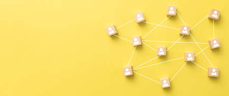 Wooden blocks connected together on blue background. Teamwork, network and community concept.の写真素材
