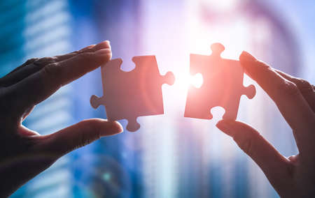 The man holds in his hand a jigsaw puzzle. Business solutions, success and strategy concept.の写真素材