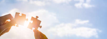 The man holds in his hand a jigsaw puzzle. Business solutions, success and strategy concept.の写真素材