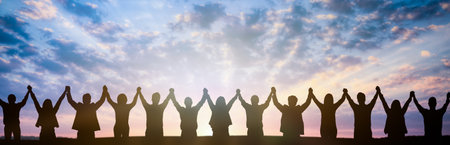 Silhouette of group happy business team making high hands over head in sunset sky background for business teamwork concept.の写真素材