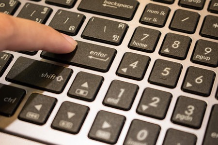 Hand of Asian woman student working on a laptop at a coffee shopの写真素材