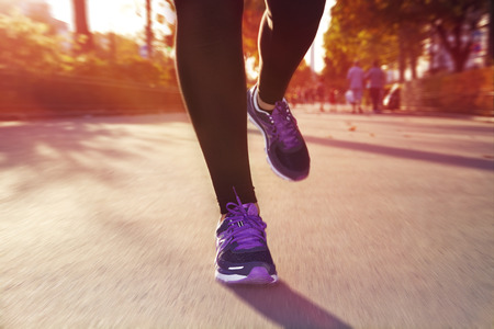 Fitness Girl running at sunset in city centerの写真素材