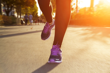 Fitness Girl running at sunset in city centerの写真素材