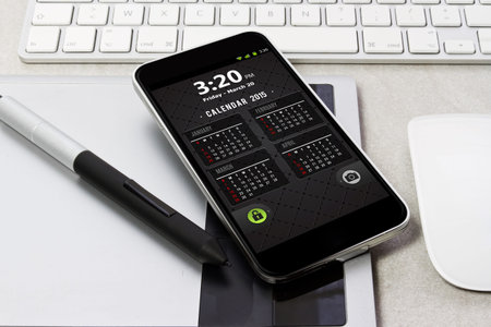 Workplace with tablet pc showing calendar on work table close-upの写真素材