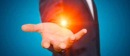 Businessman in his office holding with powerful light in his handの写真素材