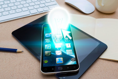 Modern mobile phone in office with lightbulb flying over