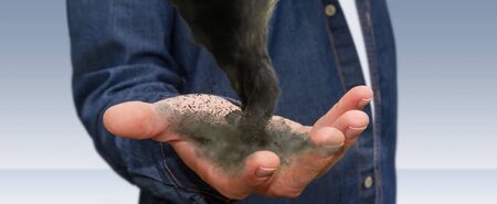 Young man holding a dark powerful tornado in his handの写真素材