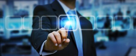 Businessman in his office pushing digital tactile buttonの写真素材