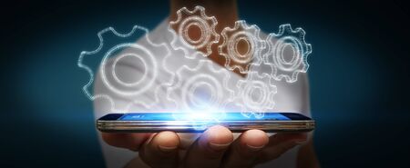 Businessman with 3D engine plan over his mobile phoneの写真素材
