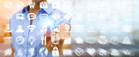 Businesswoman in his office using a digital tactile screen interface with web iconsの写真素材