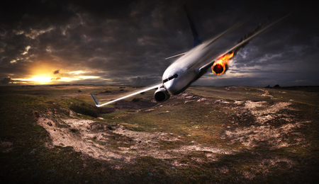 White plane with engine on fire about to crash in the landscapeの写真素材