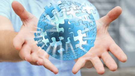 Businessman holding flying puzzle sphere in his hand ‘3D rendering’