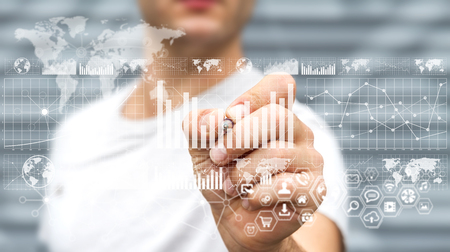 Businessman on blurred background using graph interface with a penの写真素材