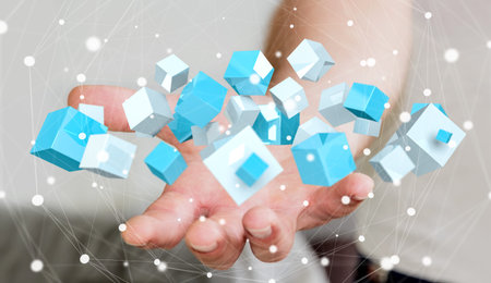 Businessman on blurred background holding flying blue shiny cube 3D rendering