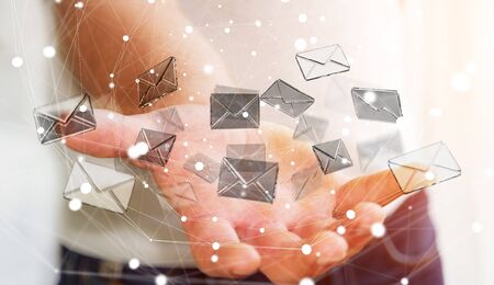 Businessman on blurred background holding 3D rendering flying email icon in his handの写真素材