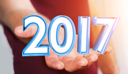 Businessman holding colorful 2017 3D rendering text in his handの写真素材