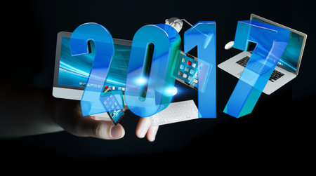 Businessman holding 2017 3D rendering text with tech device in his hand