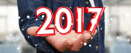Businessman holding colorful 2017 3D rendering text in his hand