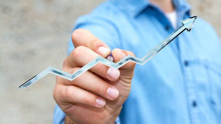 Businessman on blurred background drawing digital blue arrow with a pen 3D renderingの写真素材