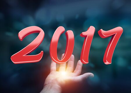 Businessman holding colorful 2017 3D rendering text in his handの写真素材