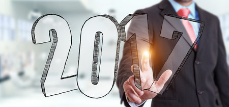 Businessman touching 2017 hand drawn text with his finger