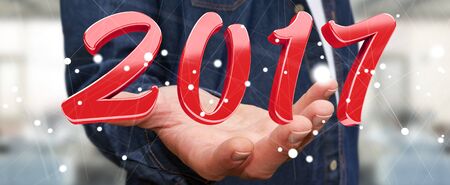 Businessman holding colorful 2017 3D rendering text in his handの写真素材