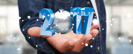 Businessman holding 2017 3D rendering text with christmas ball in his hand