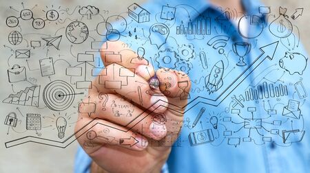 Businessman on blurred background drawing manuscript project presentation with a penの写真素材