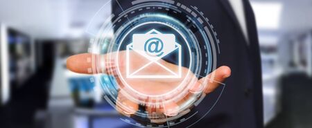 Businessman on blurred background holding 3D rendering flying email icon in his handの写真素材