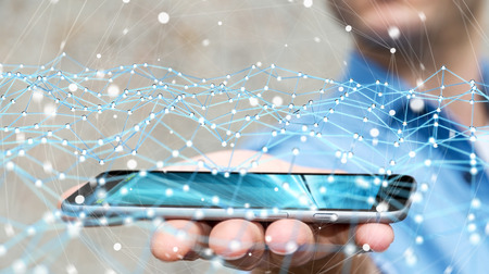 Businessman on blurred background holding flying network over phone 3D renderingの写真素材