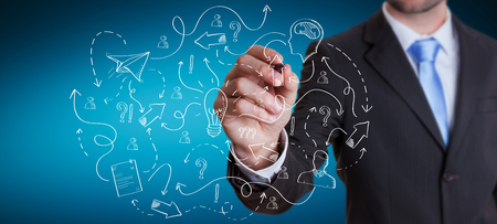 Businessman on blurred background drawing manuscript project presentation with a penの写真素材