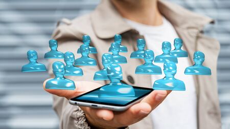 Businessman on blurred background with shiny glass avatar group over mobile phone 3D renderingの写真素材