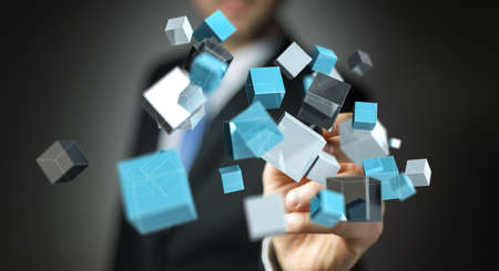 Businessman on blurred background holding floating blue shiny cube network 3D renderingの写真素材